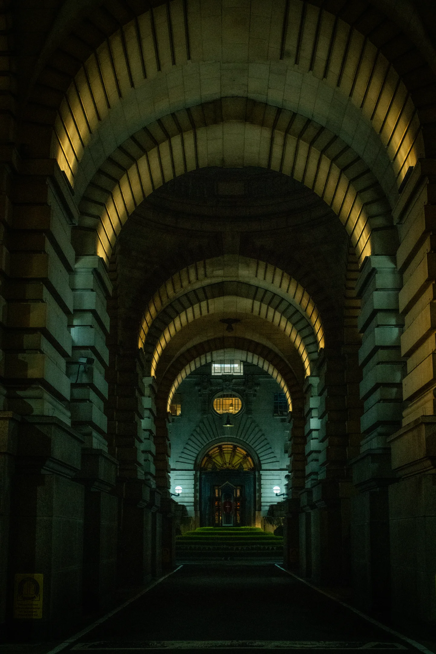 A symmetrical stone arcade recedes toward a distant illuminated landing.
