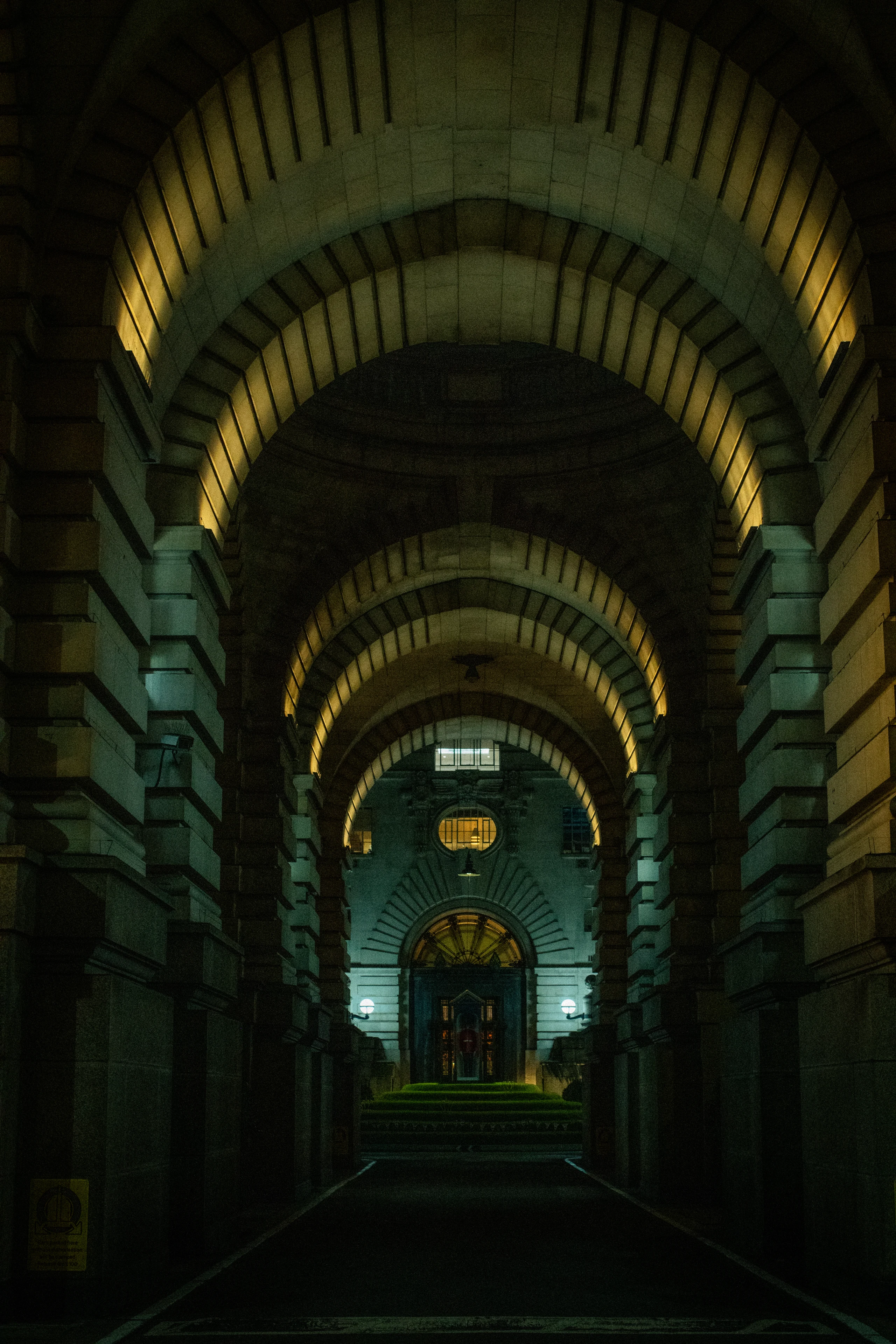 A symmetrical stone arcade recedes toward a distant illuminated landing.