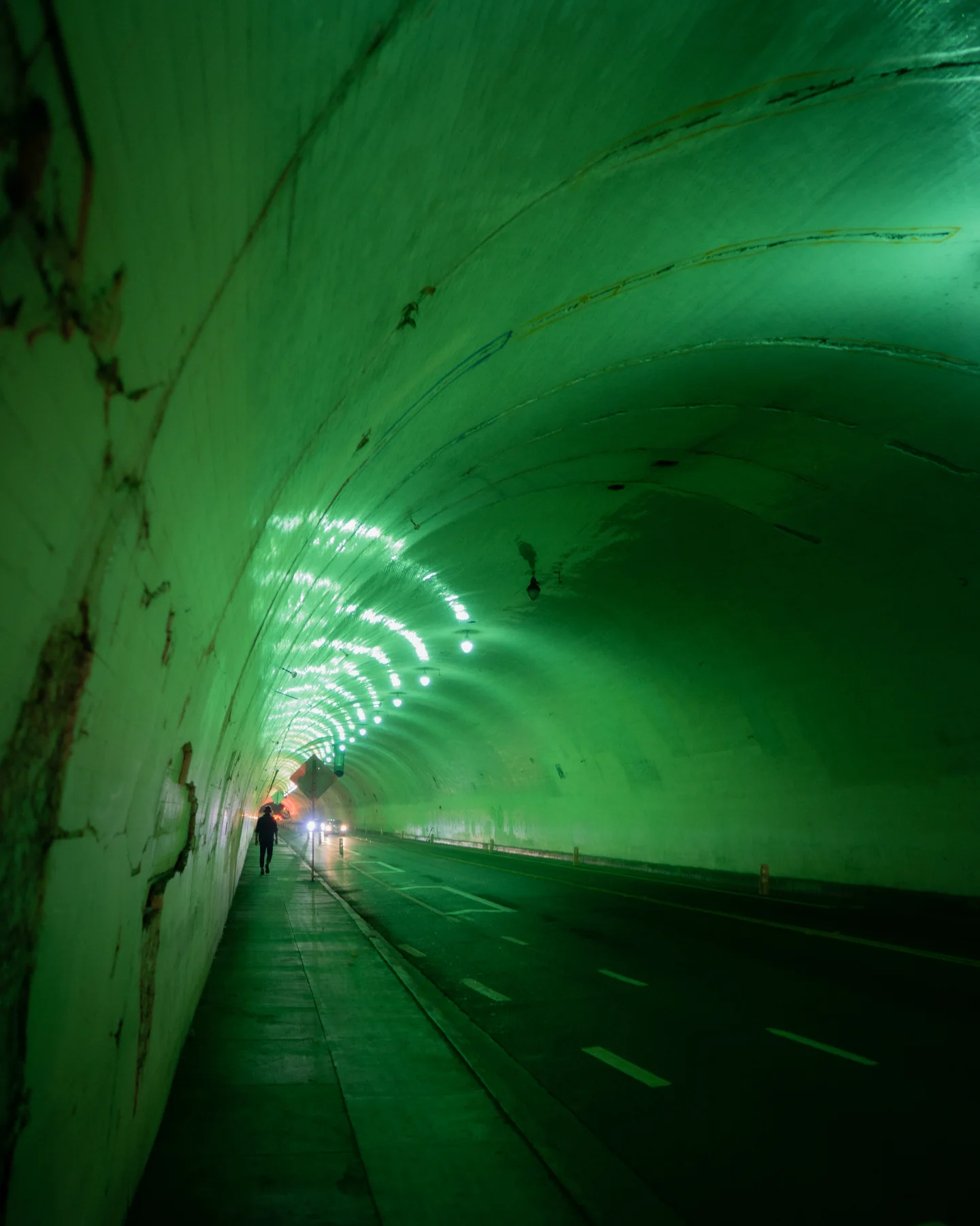 Figure moving through a tunnel illuminated in green.