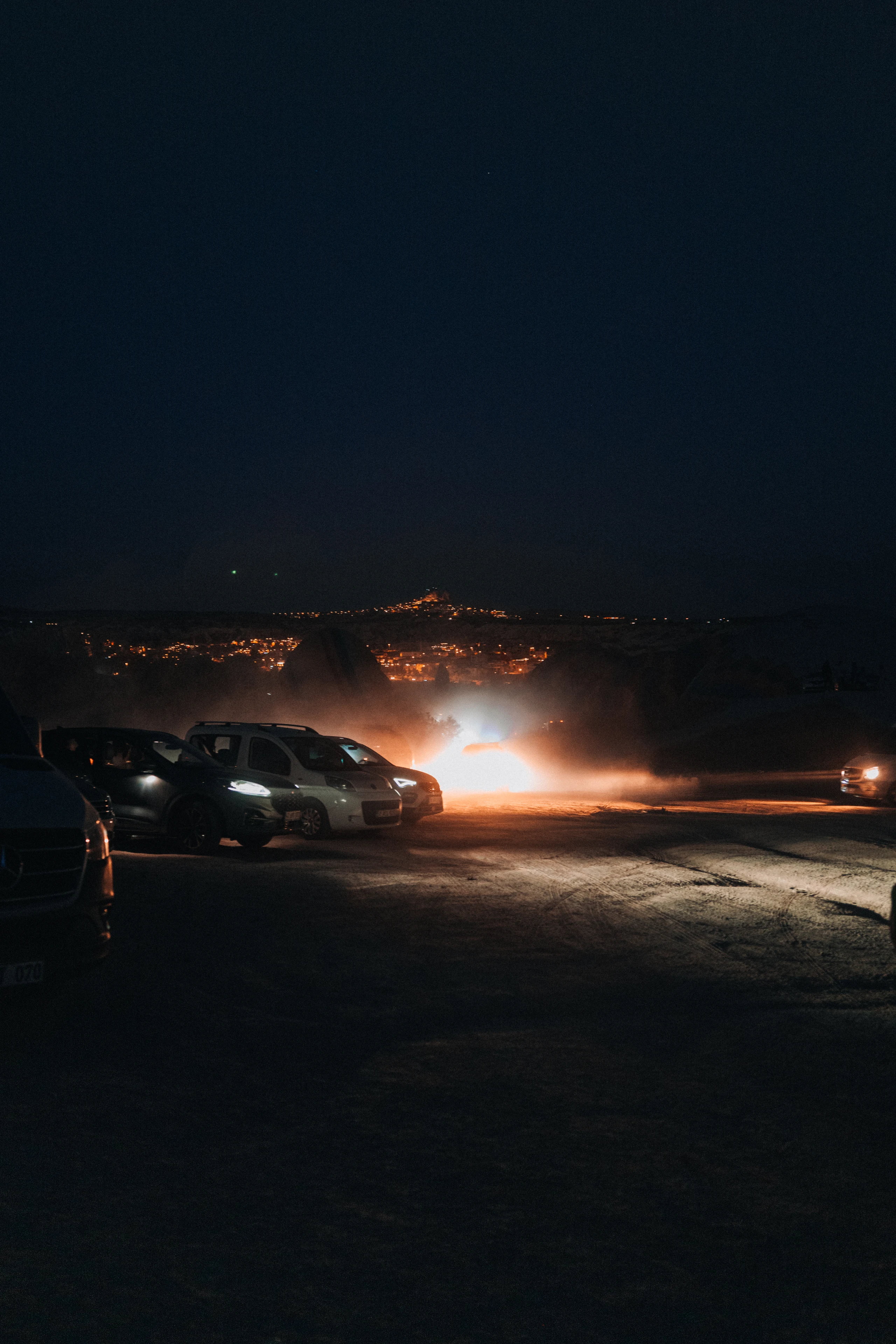Car headlights approaching through the darkness.