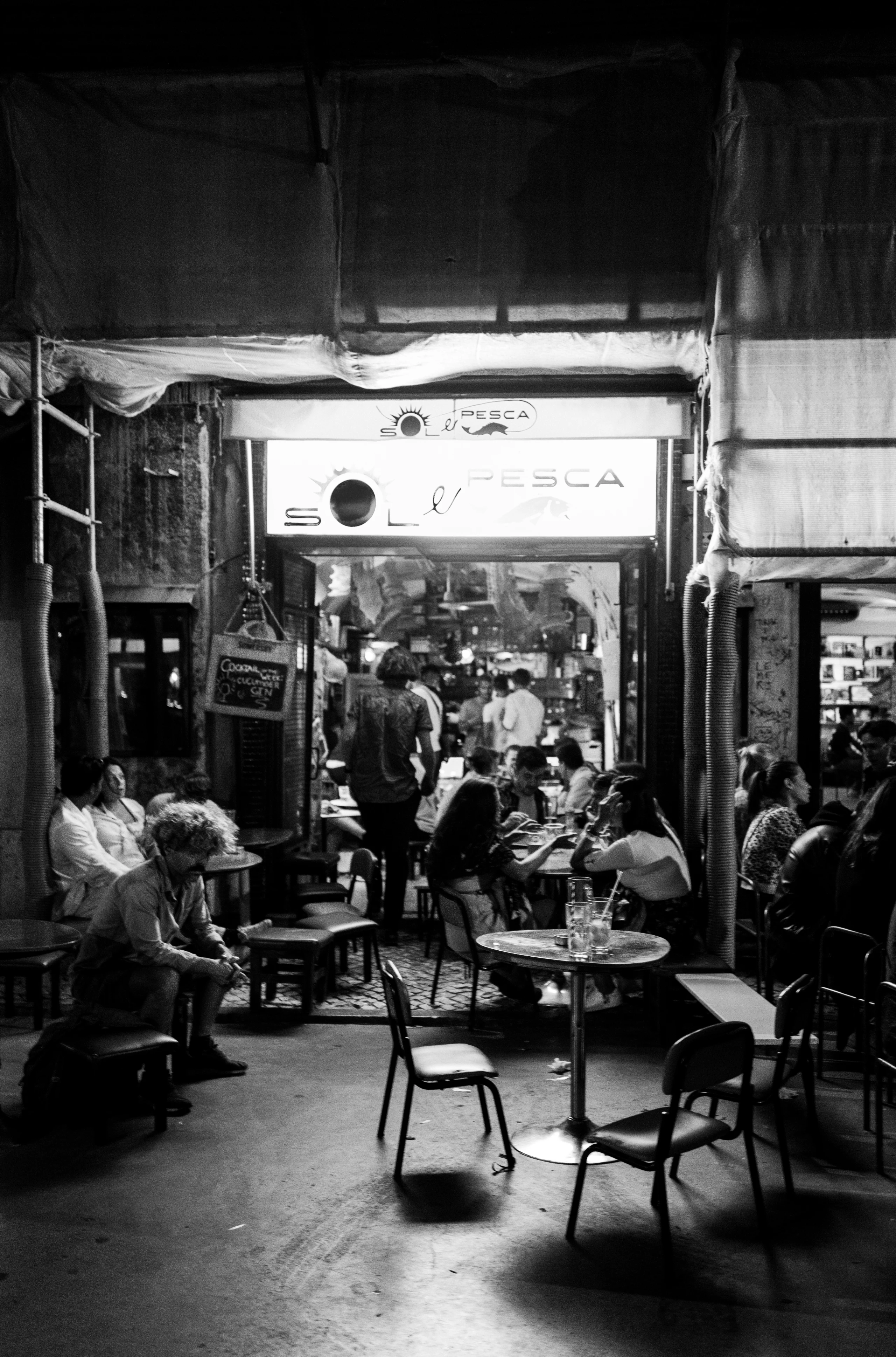 Diners gather in a warmly lit open-front restaurant.