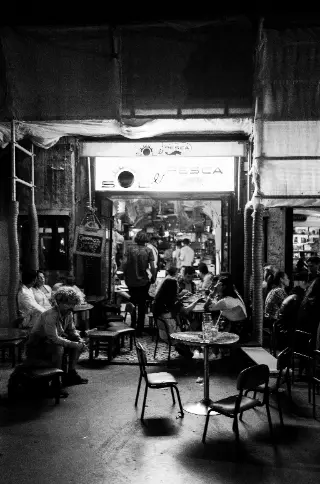 Diners gather in a warmly lit open-front restaurant.