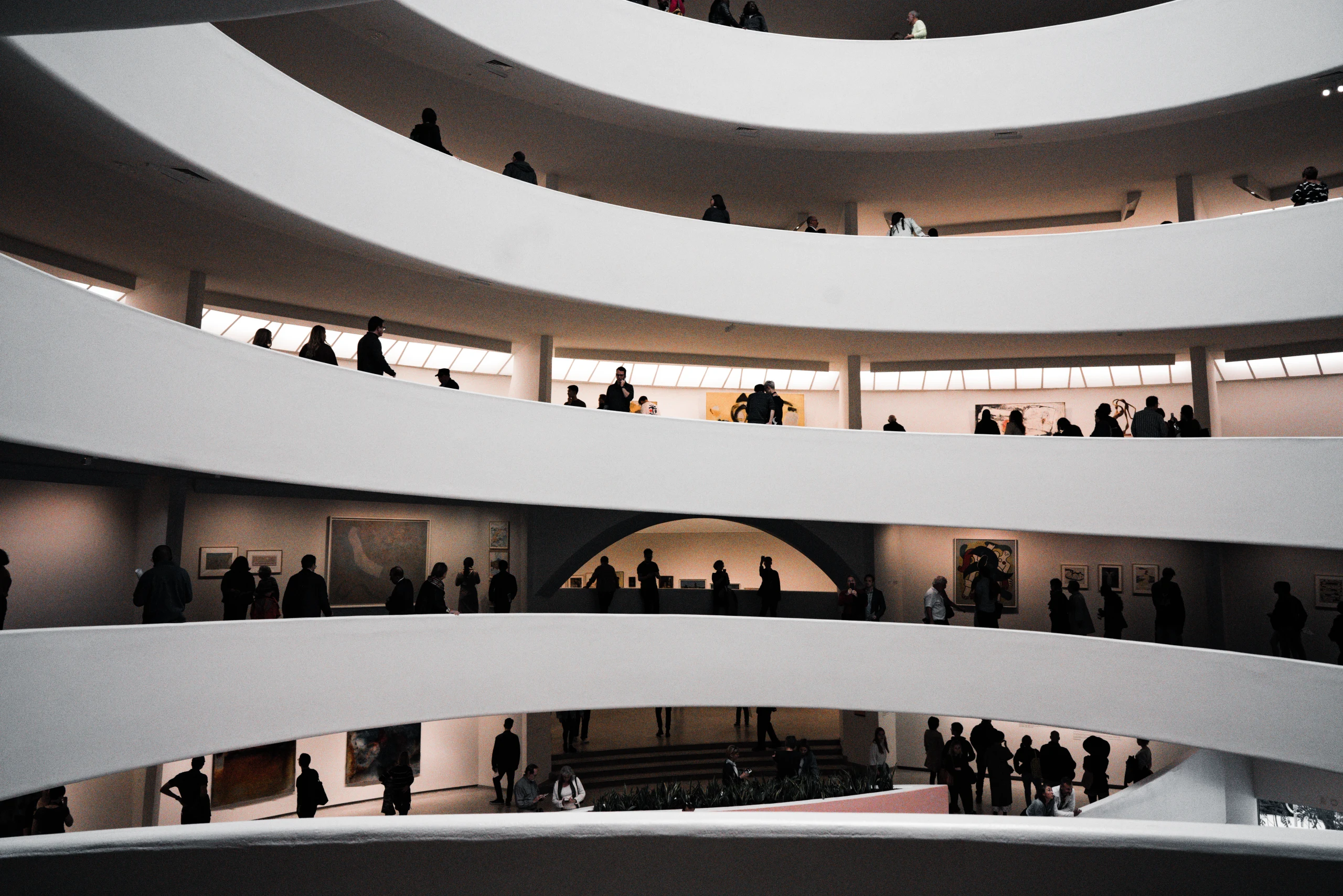 People silhouetted along several levels of the Guggenheim Museum spiral.