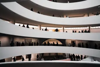 People silhouetted along several levels of the Guggenheim Museum spiral.
