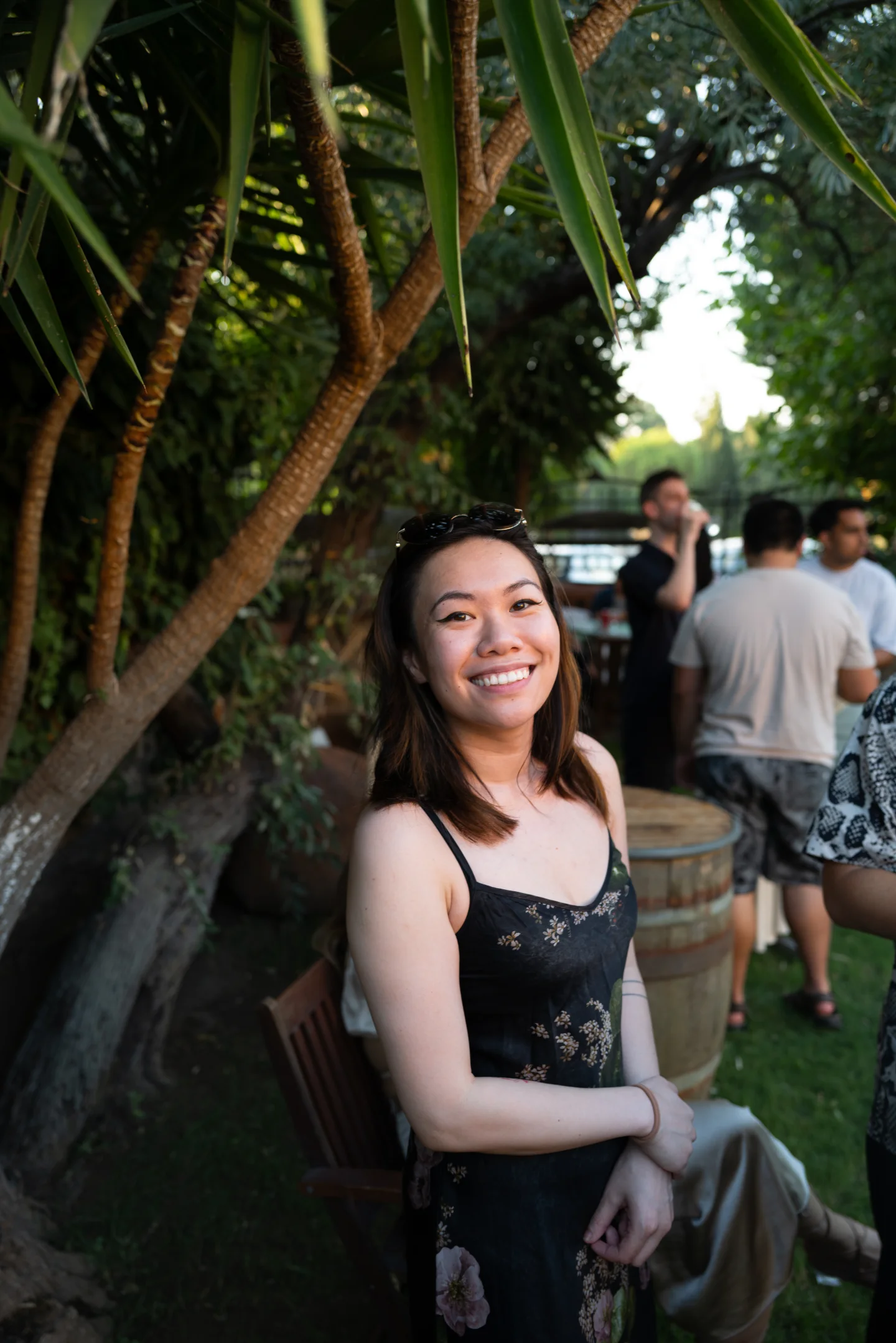 A woman smiles beside a tree at the reception.