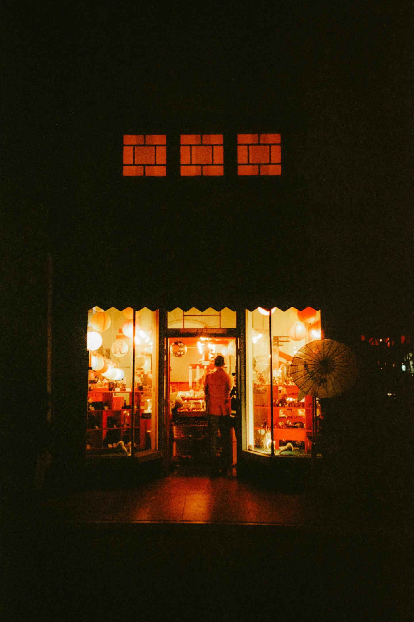 Small storefront glowing alone in the darkness.