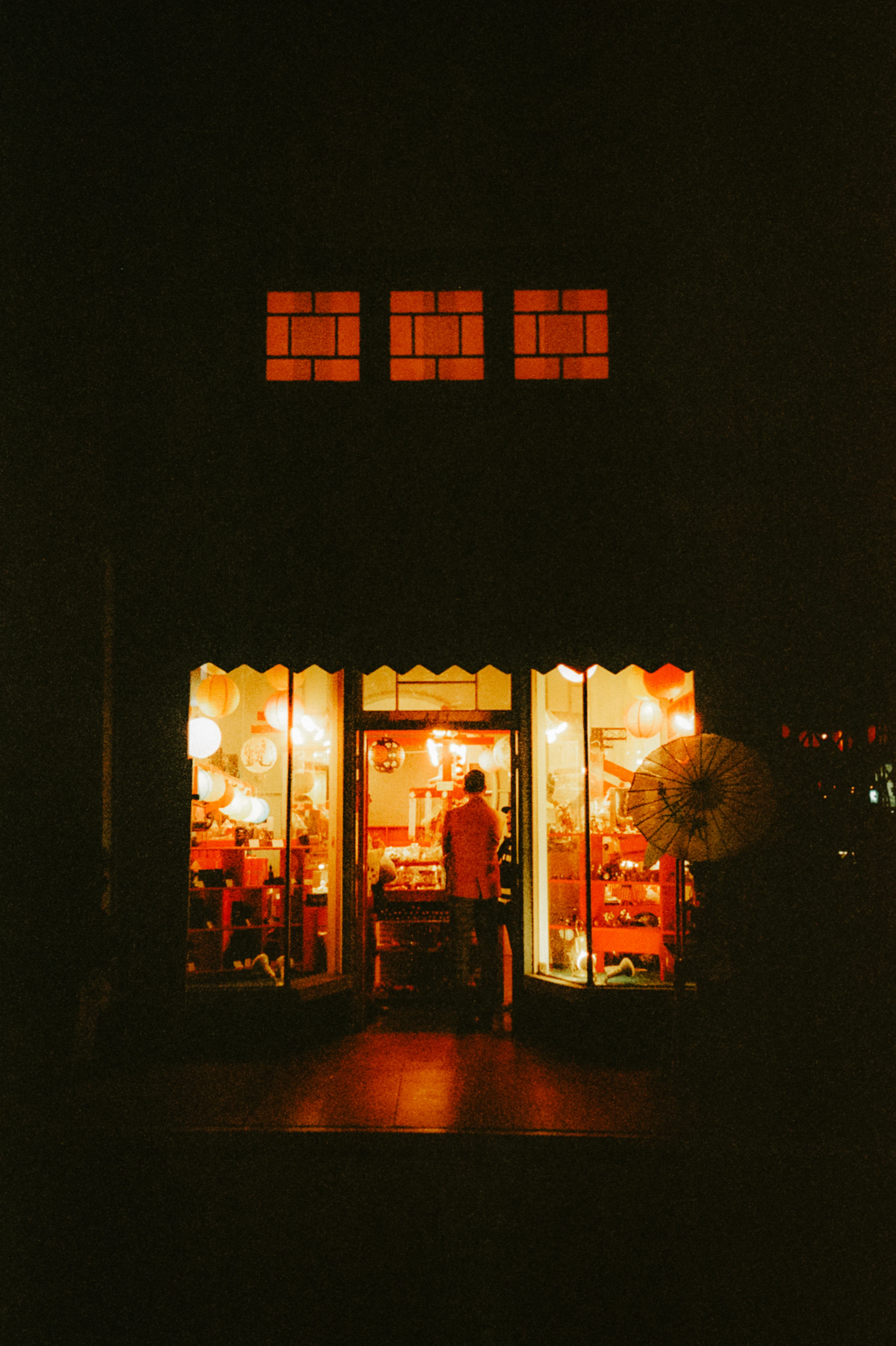 Small storefront glowing alone in the darkness.