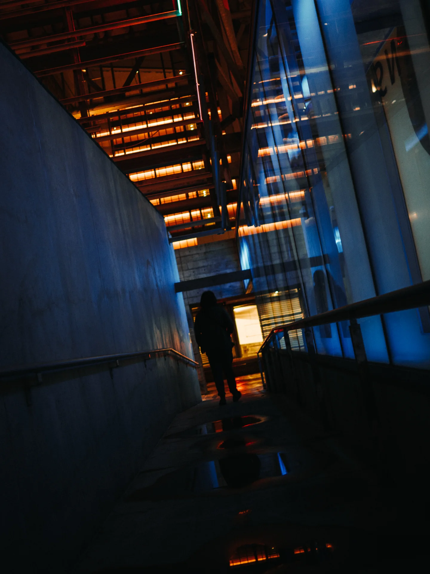 Blue shafts of light crossing an industrial passage.