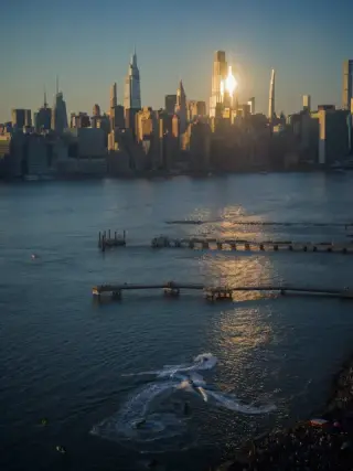 Late sun reflects from the Manhattan skyline across the East River.
