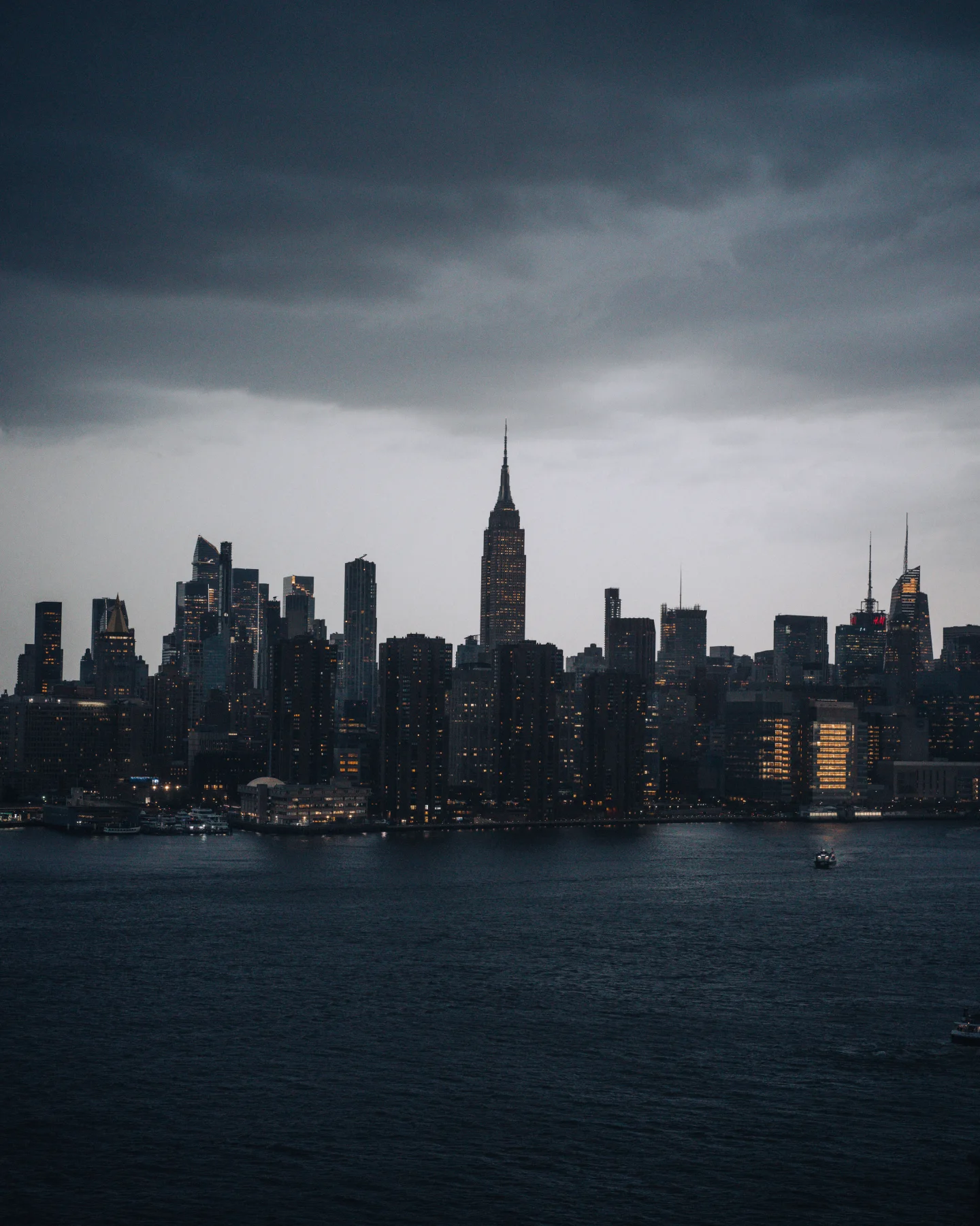 Dark storm clouds hanging over the Manhattan skyline across the East River.