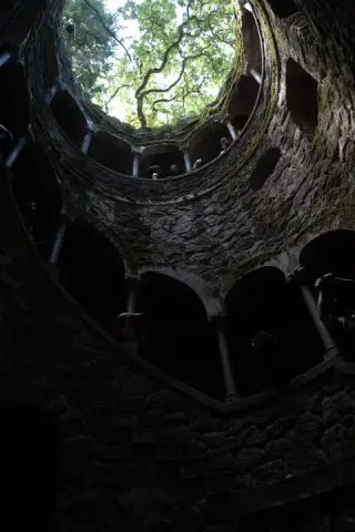 A circular stone opening frames trees high above.