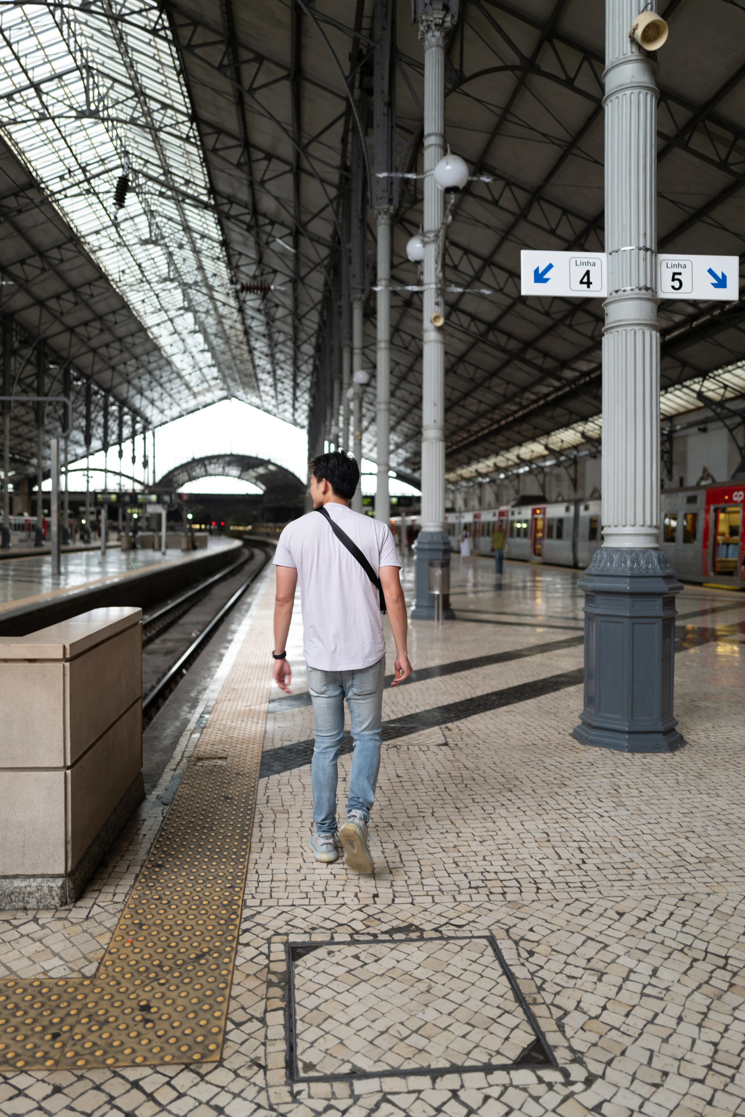 A lone traveler walks along a quiet station platform.