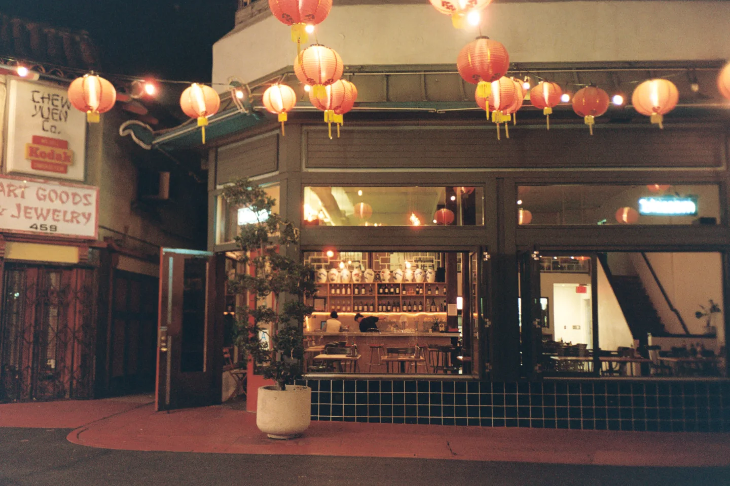 Paper lanterns hanging above a nighttime storefront.