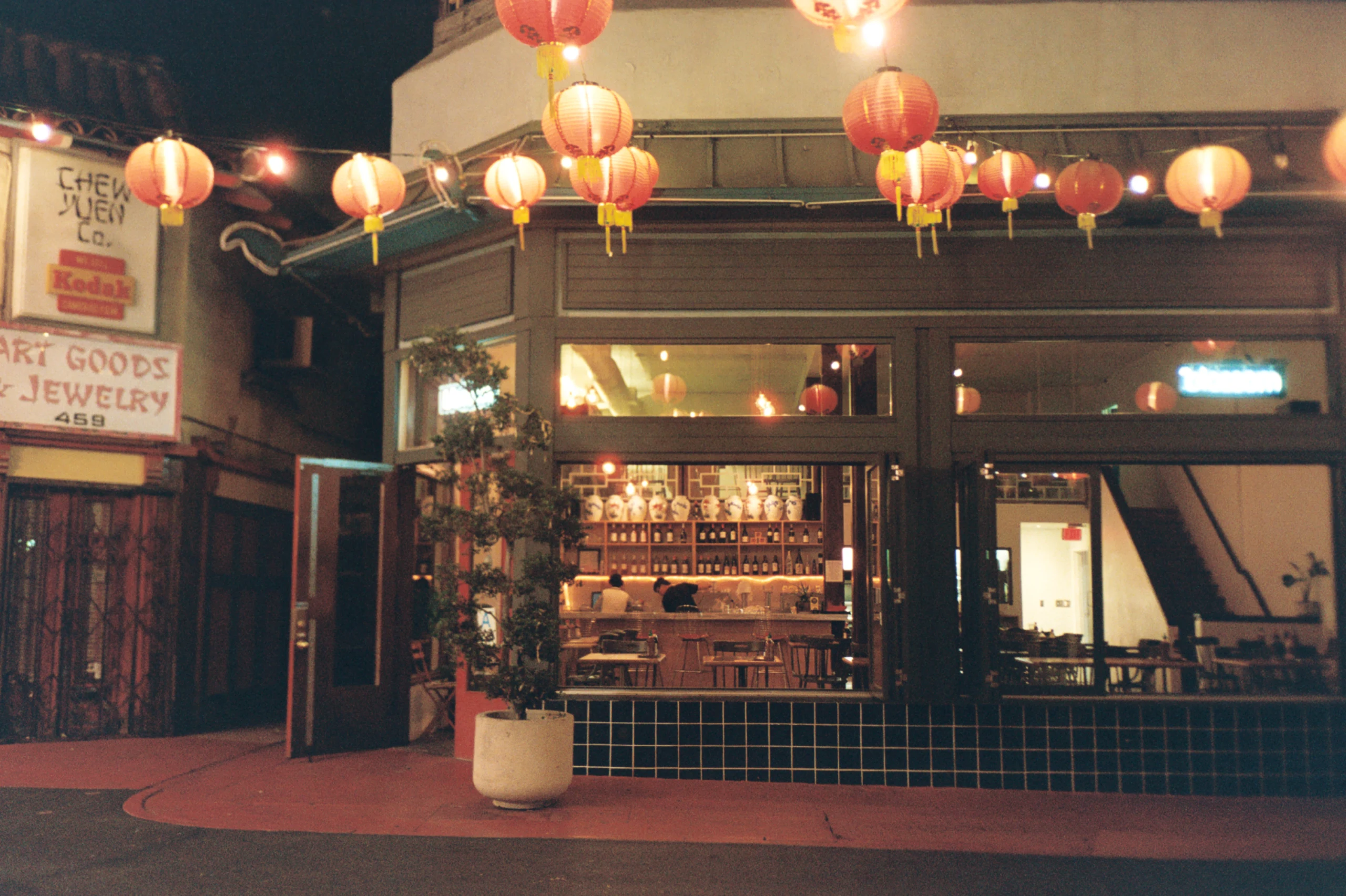Paper lanterns hanging above a nighttime storefront.