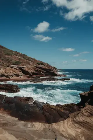Surf breaking across a rocky shoreline.