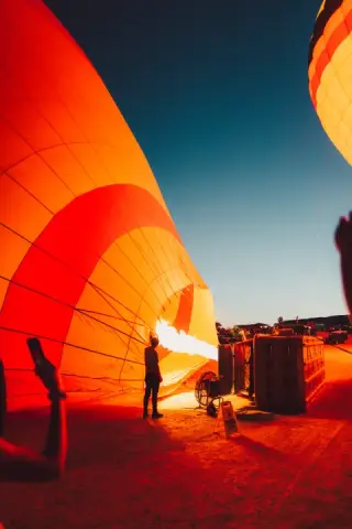 Worker silhouetted inside a glowing red hot-air balloon.