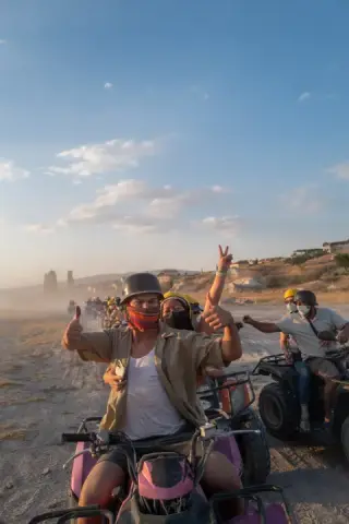 Group smiling together on all-terrain vehicles.