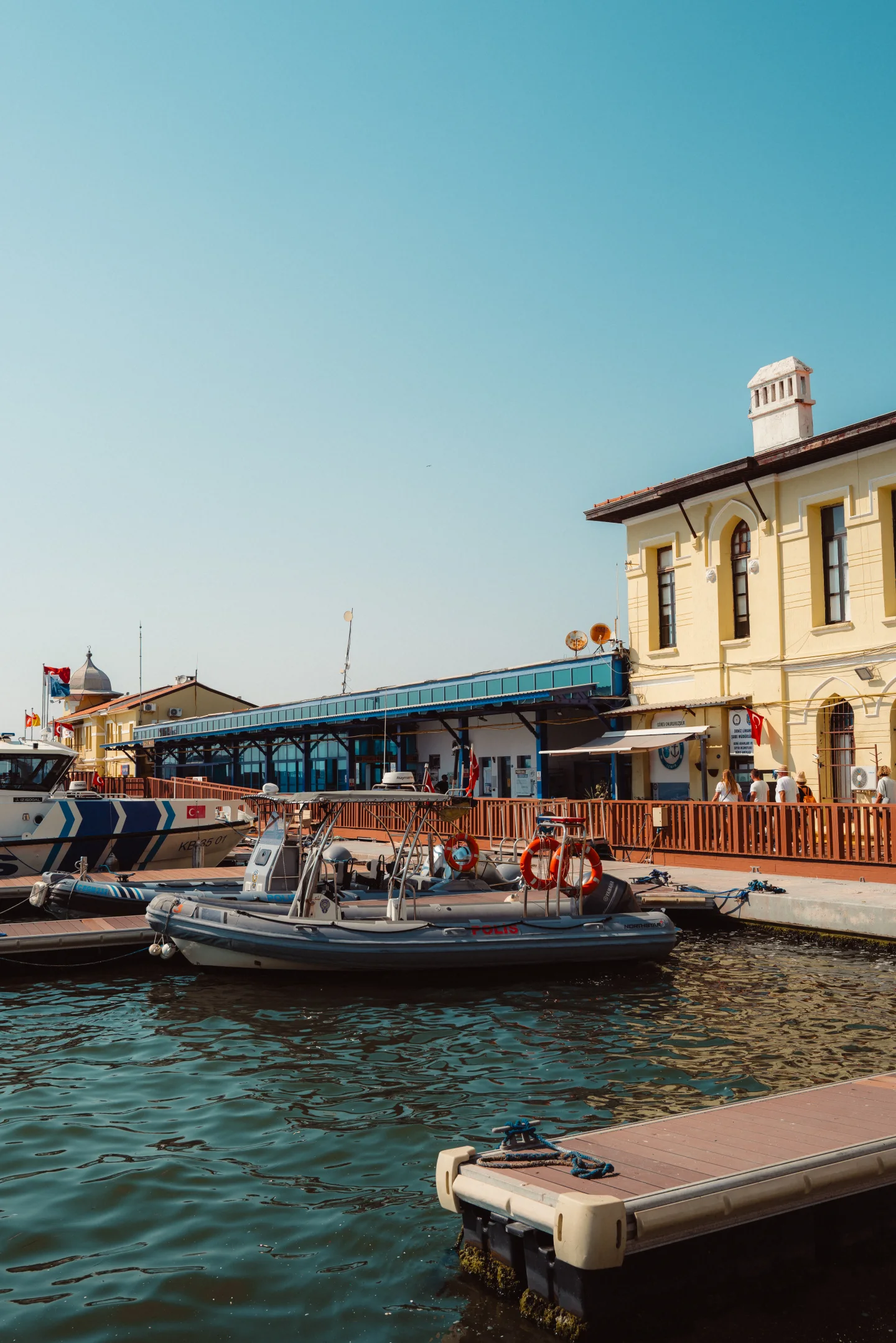 Small boats are moored beside a waterfront terminal in İzmir.