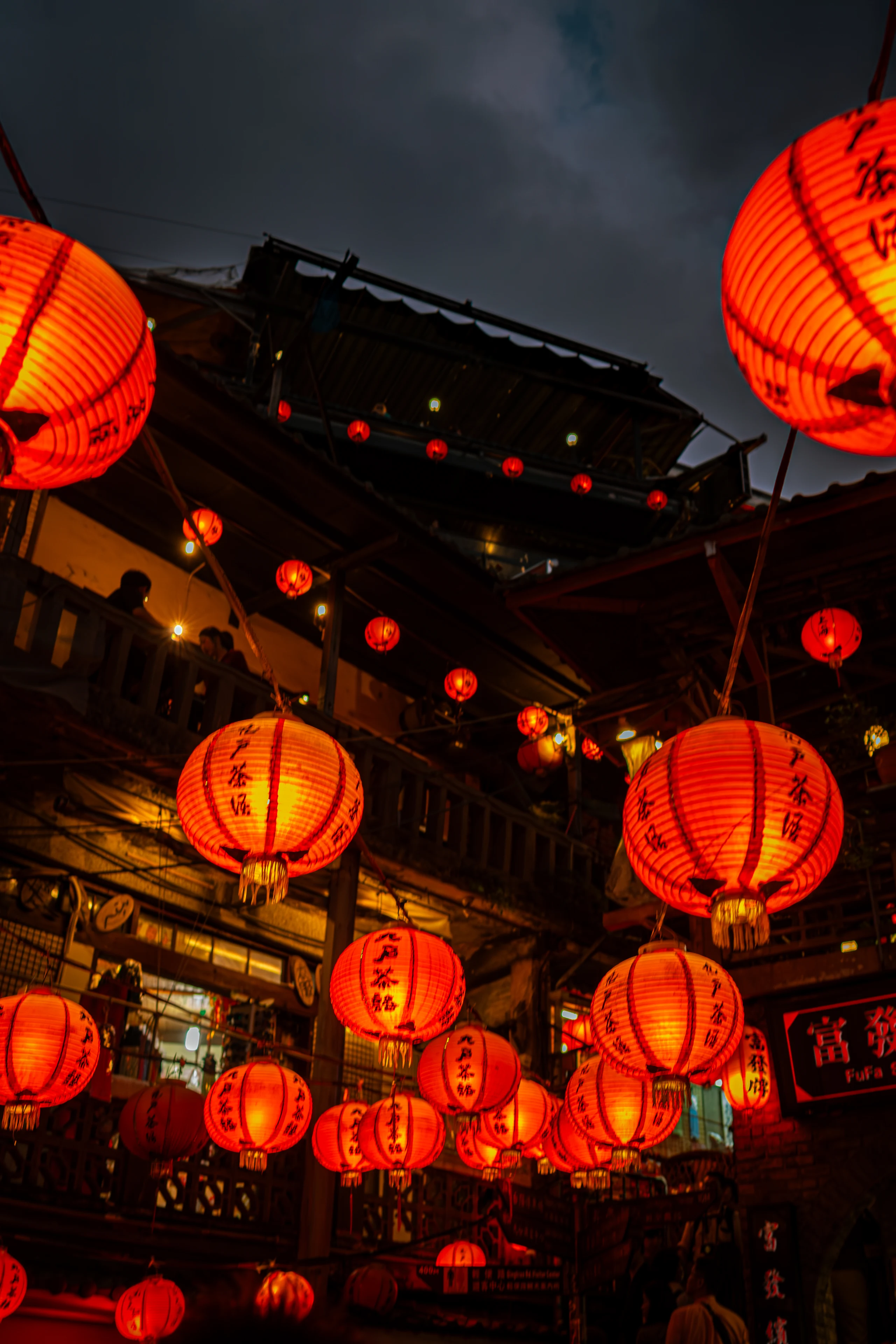 Close view of red lanterns hanging above a market.