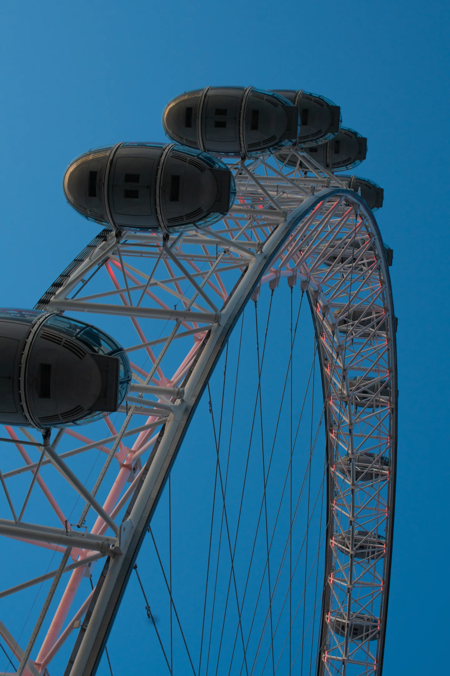 Upper section of the London Eye photographed against a clear blue sky.
