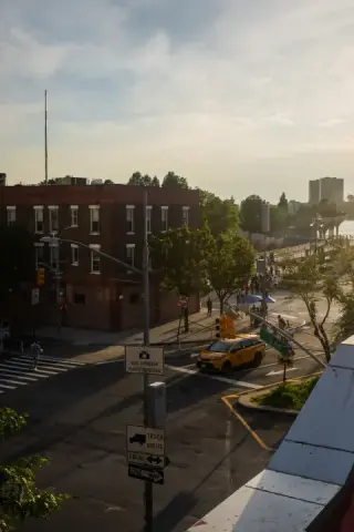 Sunlit city intersection with a yellow taxi viewed from above