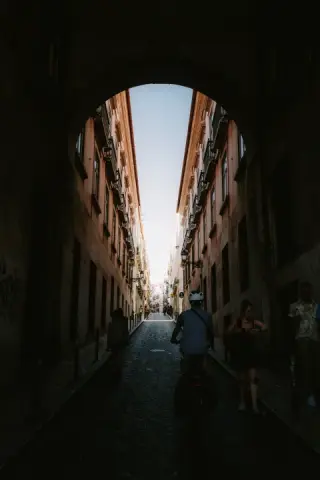 A deep shadow frames a bright narrow street.