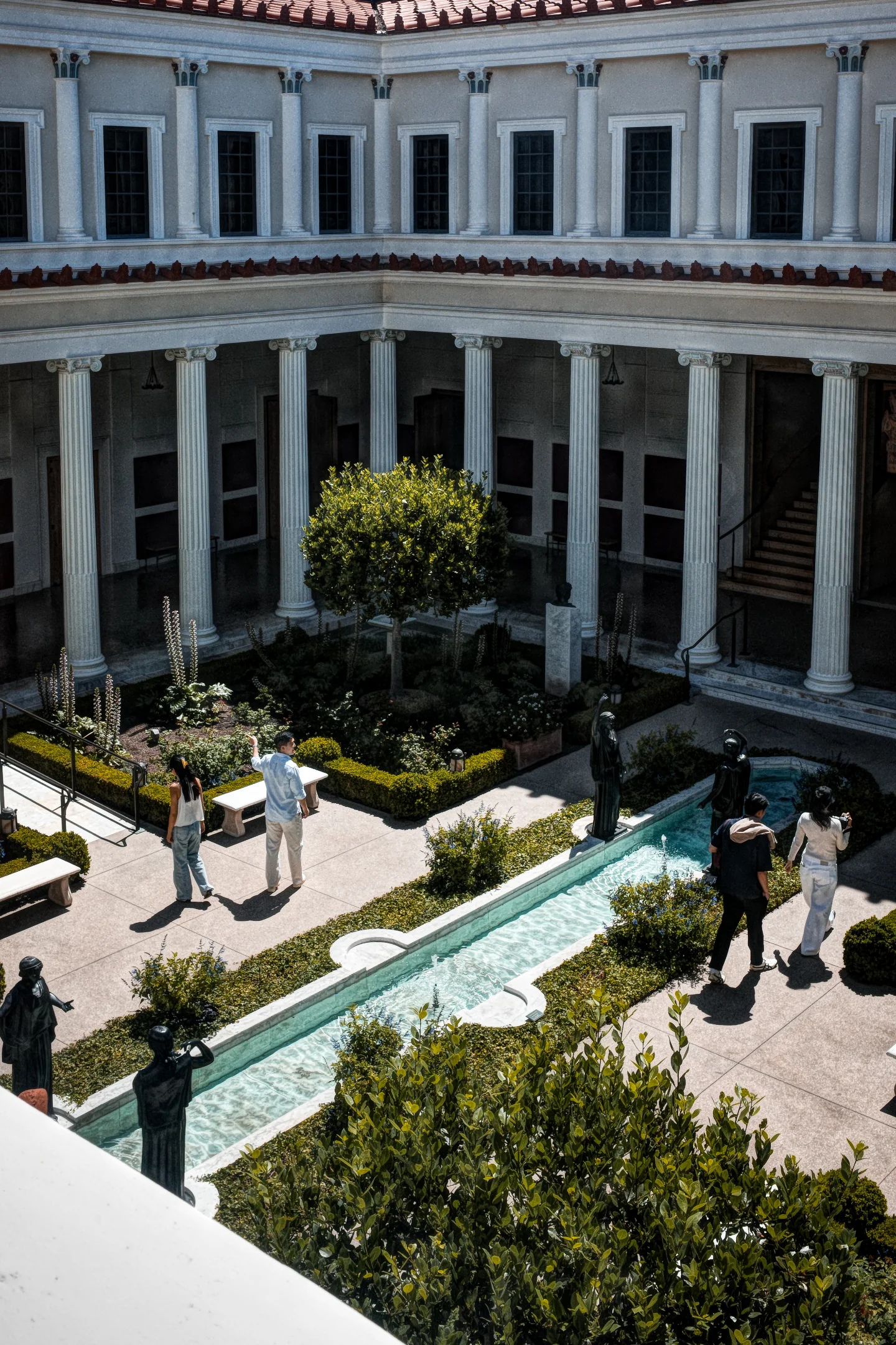 People walking through the Getty Villa peristyle garden and reflecting pool