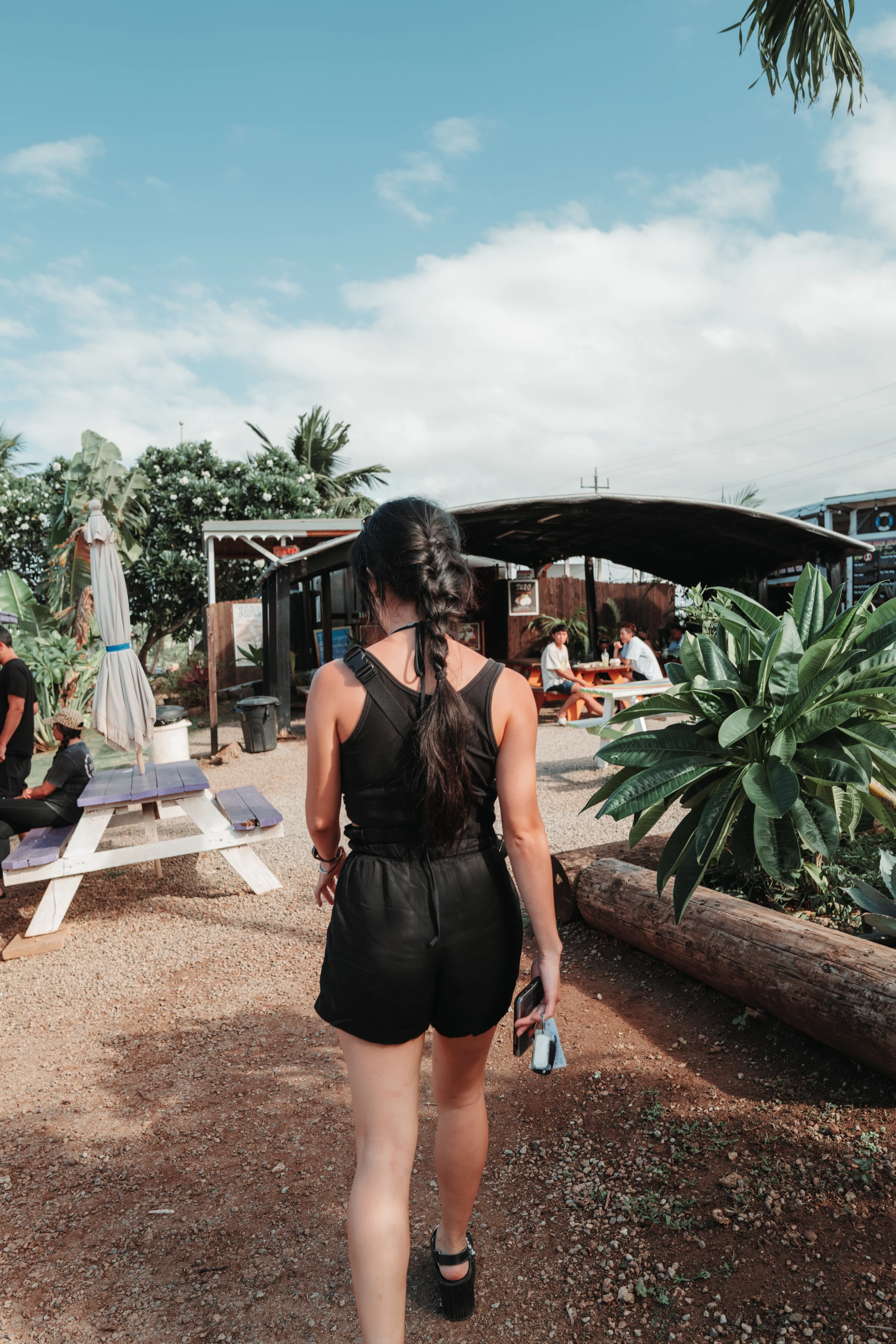 Woman walking along a tropical garden path.