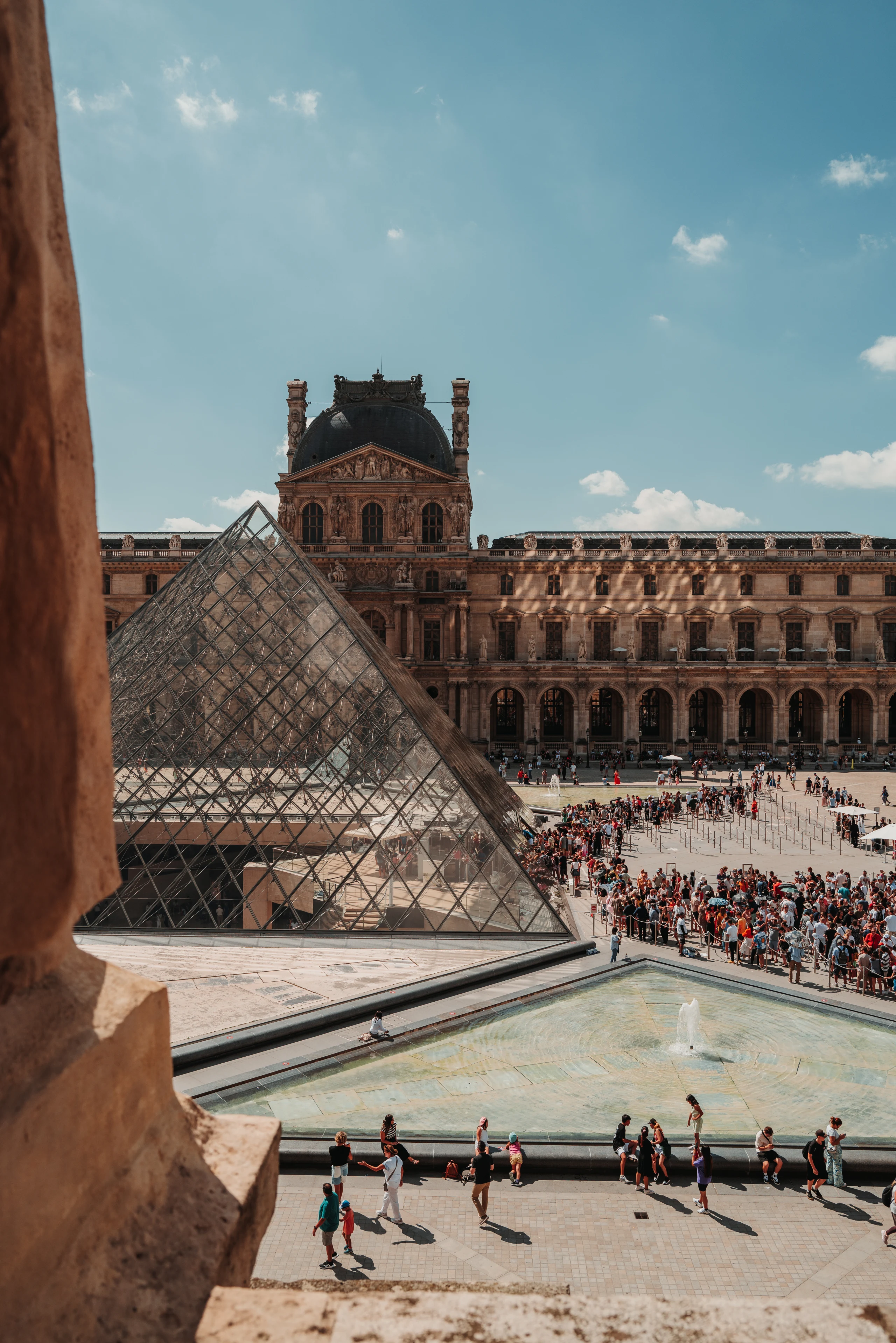 Louvre pyramid seen through a stone opening.