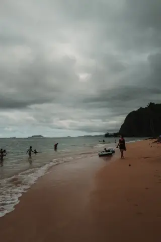 Small figures scattered across an overcast beach.
