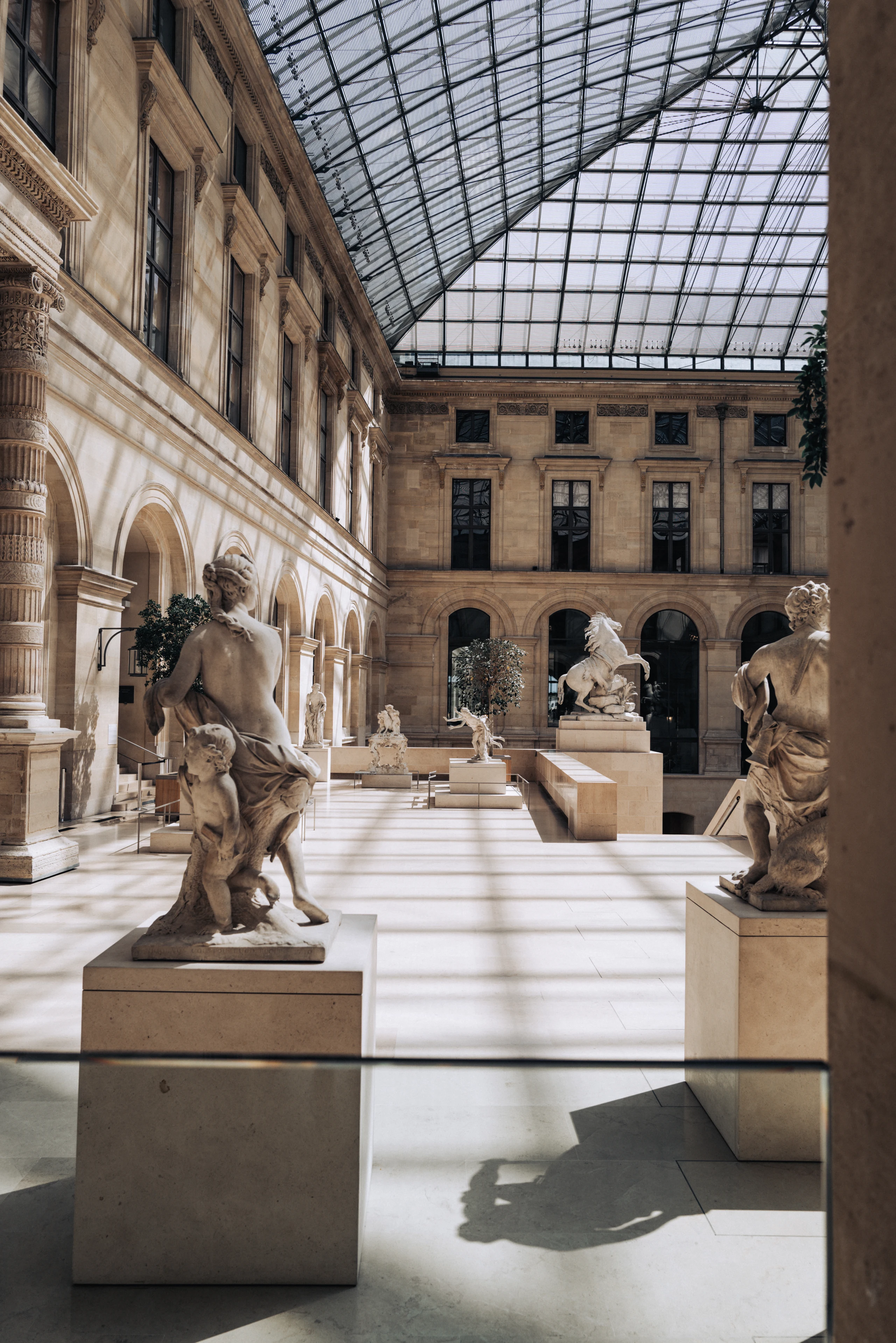 Classical sculptures beneath the Louvre's glass courtyard roof.