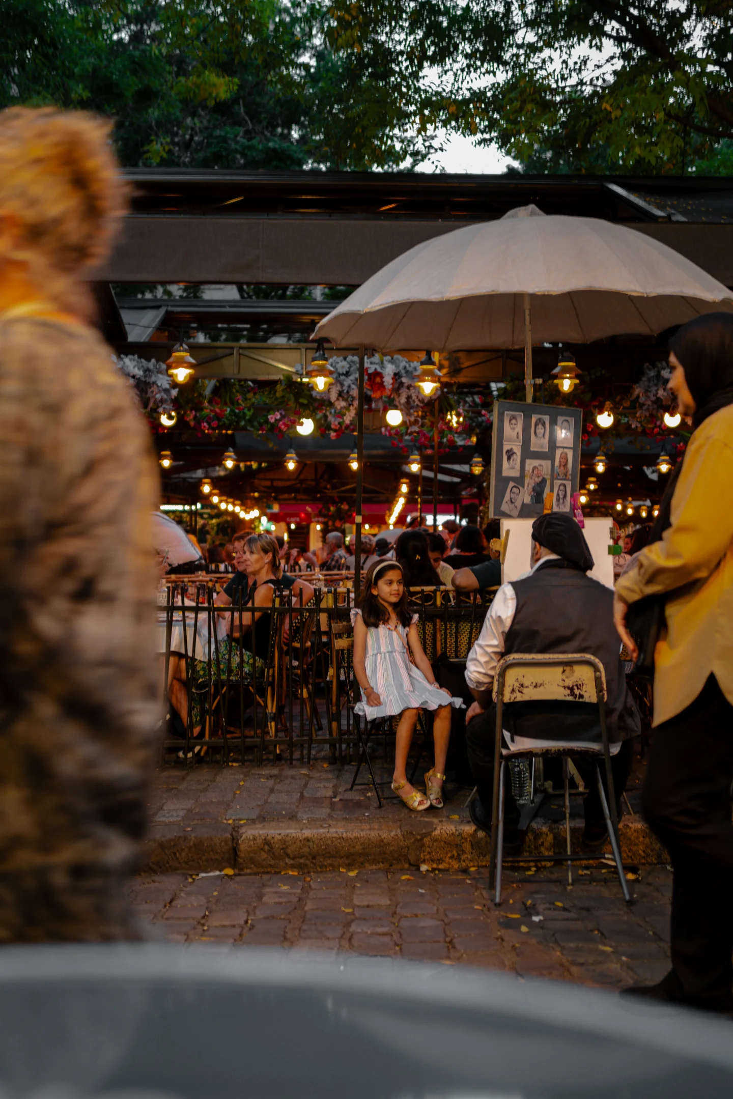 Restaurant patio seen beyond a passing pedestrian.