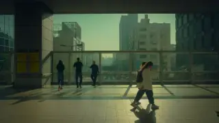 Pedestrians cast long shadows inside a glass-walled station.