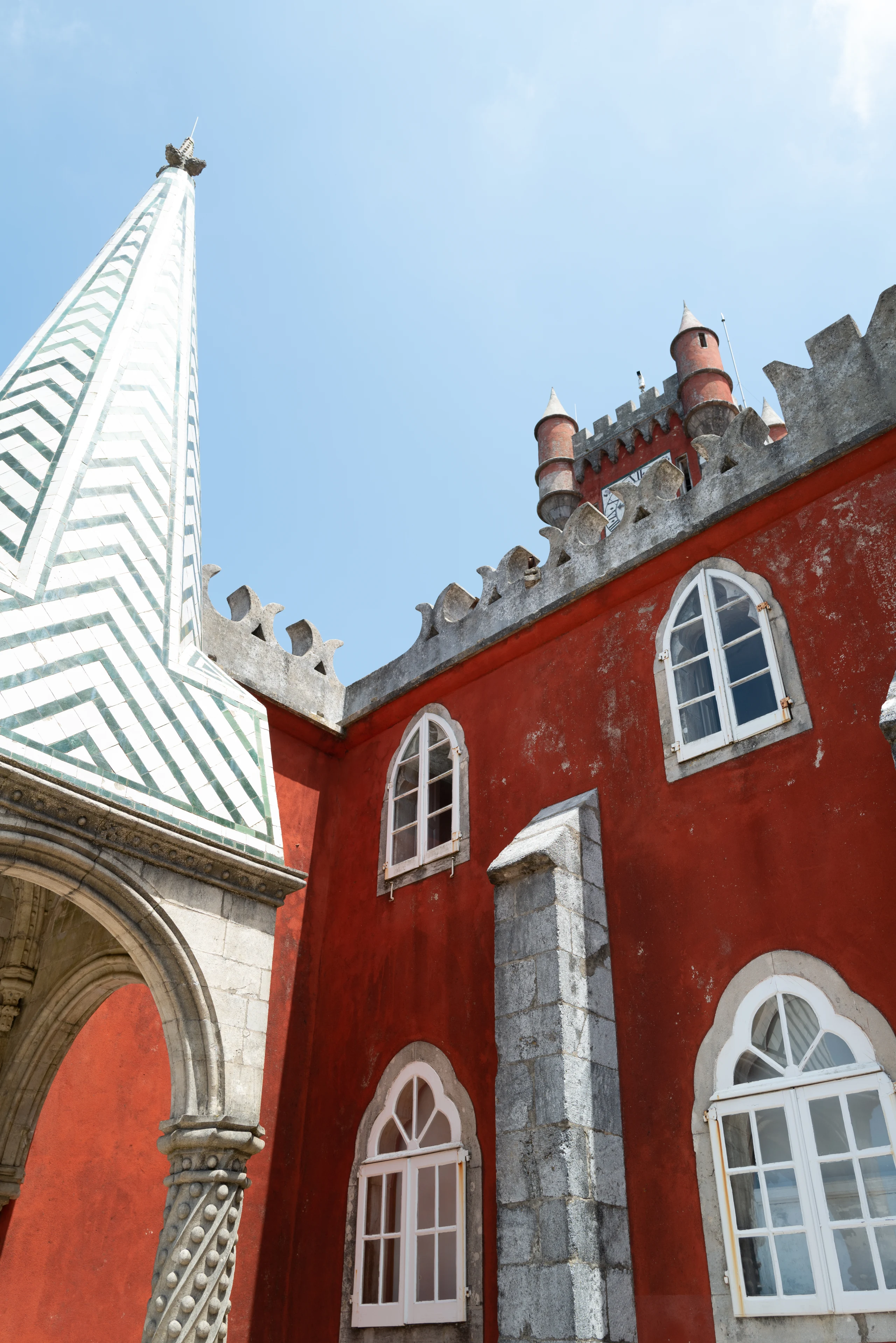 White-trimmed windows pattern a deep red palace wall.