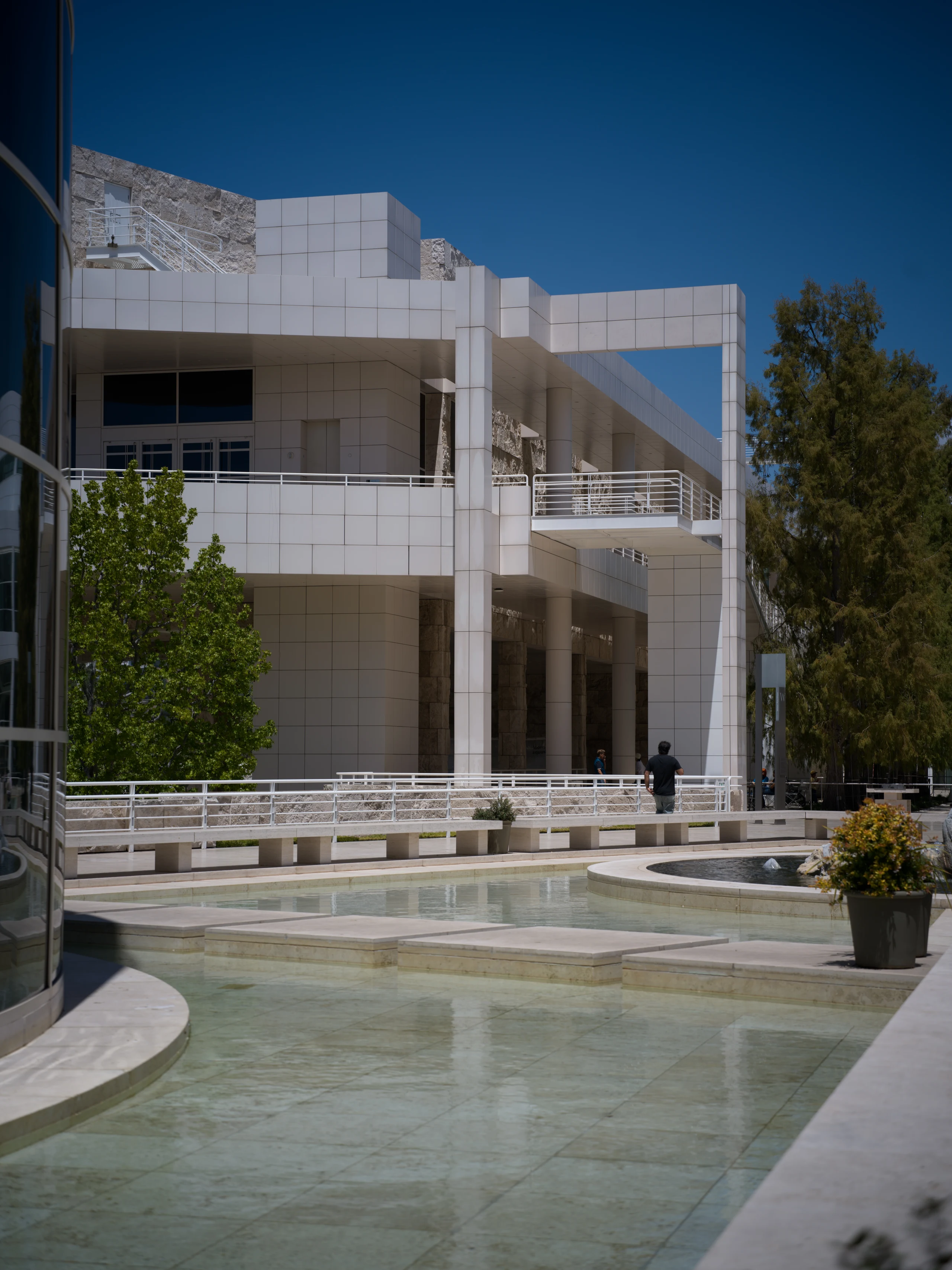 White modern Getty Center buildings and shallow plaza pool under a blue sky