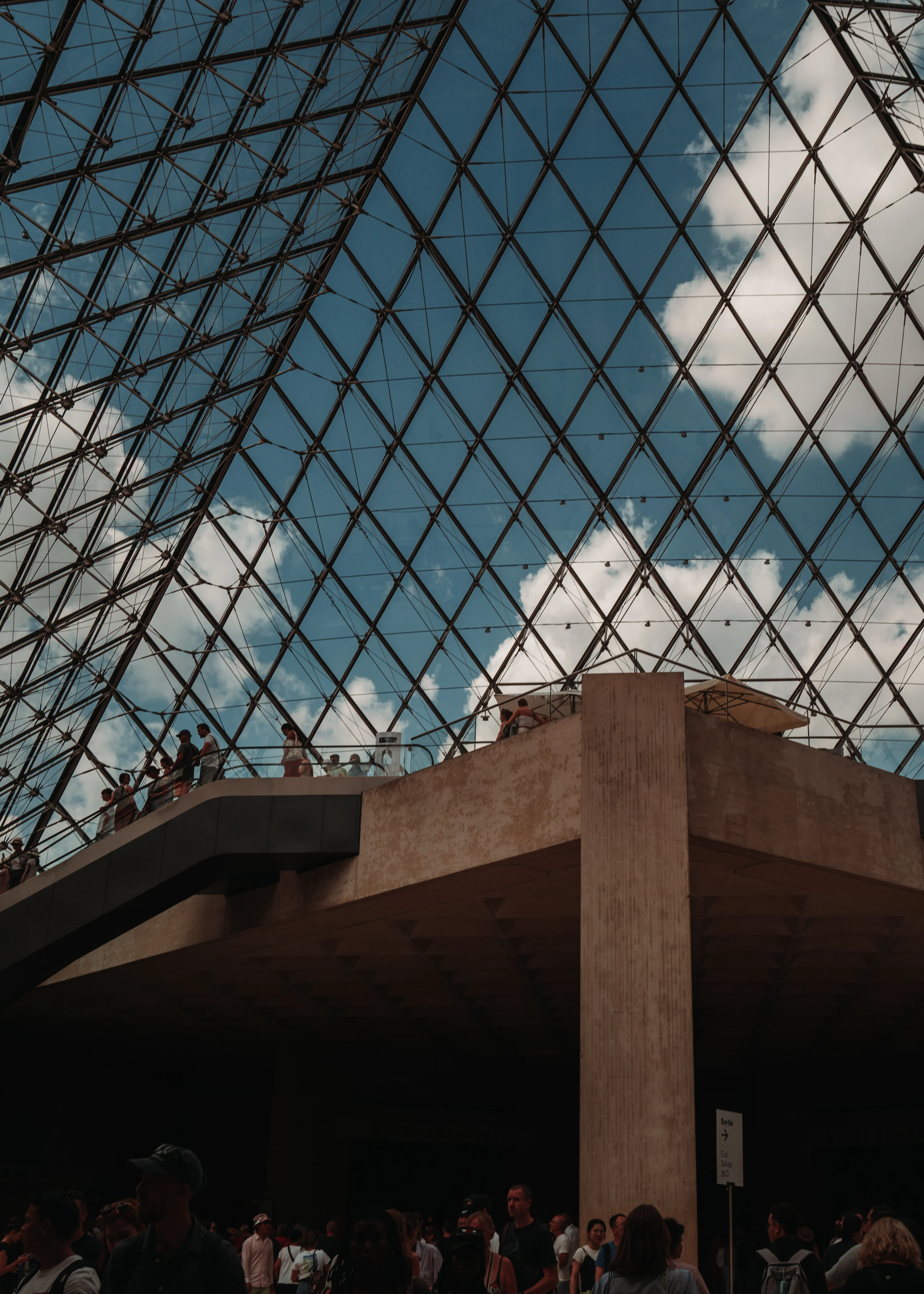 Geometric view of the Louvre pyramid against the sky.